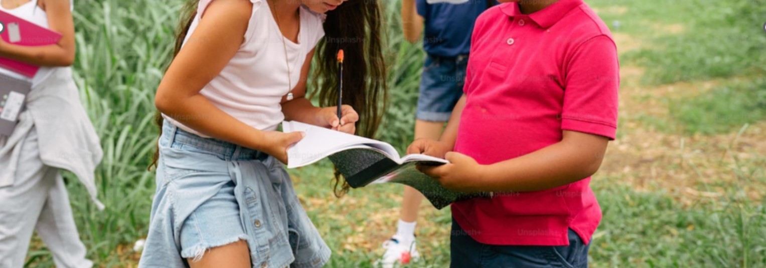 girl helping boy to read a book