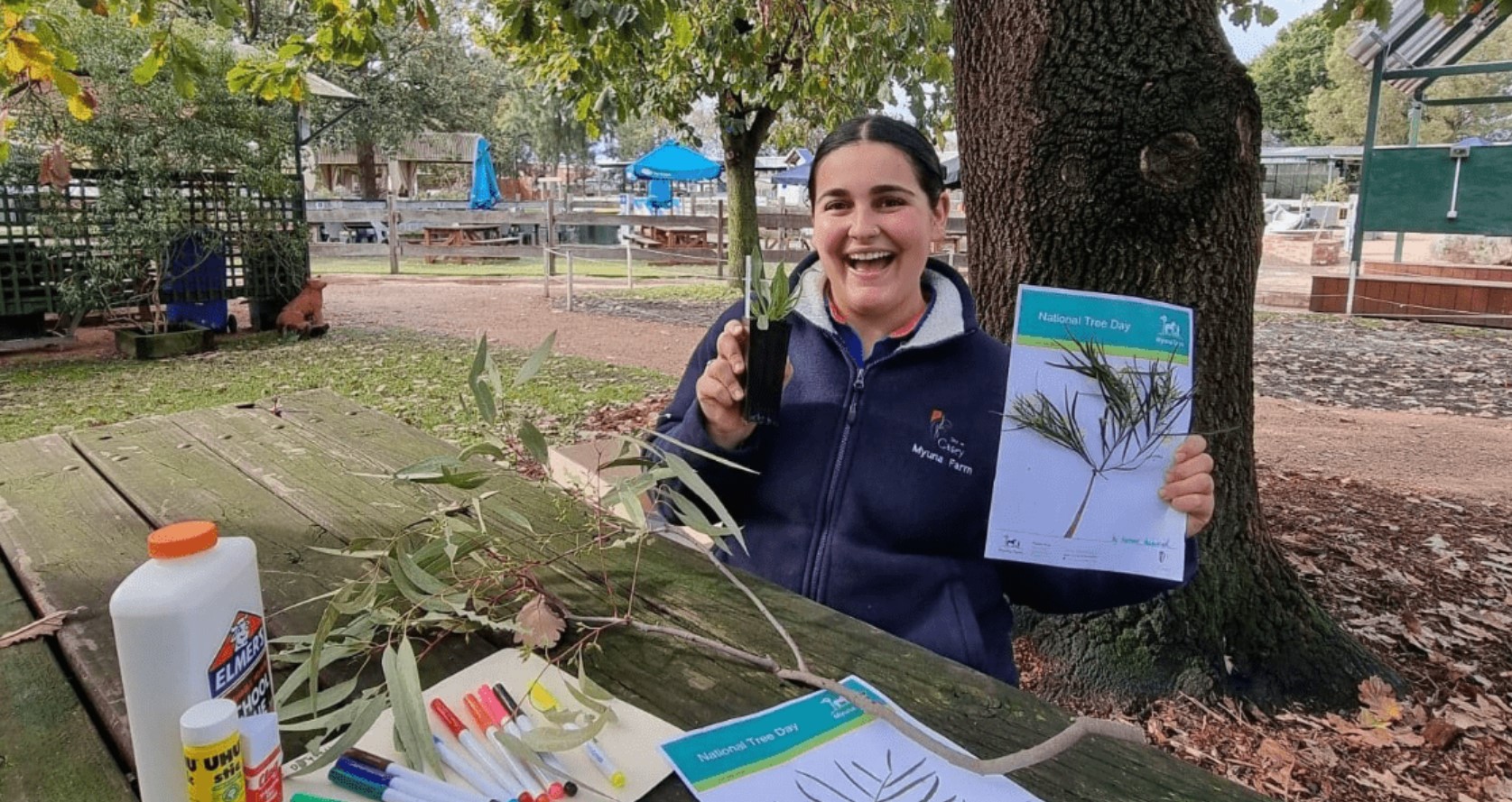 lady holding up brochure and plant at myuna farm